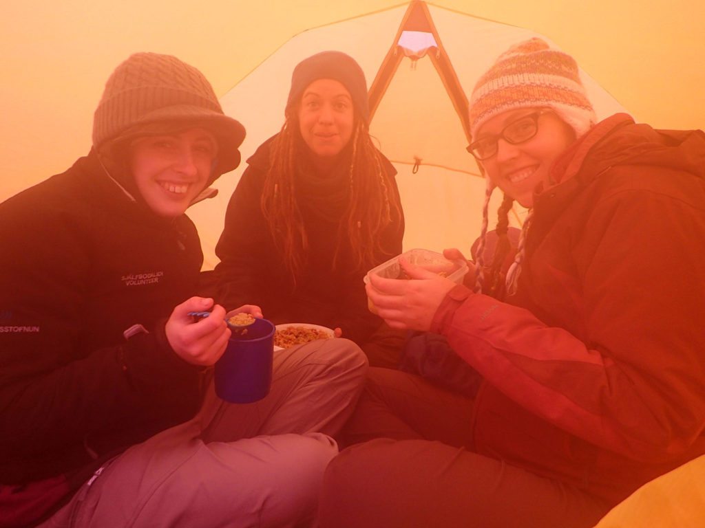 Hele gruppen har søgt ly for uverjret og spiser aftensmad i Alines telt. Foto: Aline Boer.